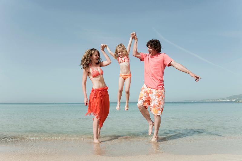 Eine Familie macht im Familienurlaub Mallorca All Inclusive günstig einen Strandspaziergang