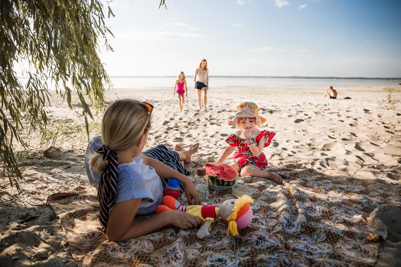 Eine Familie entspannt im All Inclusive Familienurlaub Mallorca beim buddeln am Strand