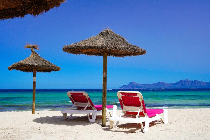 Pinke Sonnenliegen unter einem Sonnenschirm im Familienurlaub Mallorca All Inclusive günstig