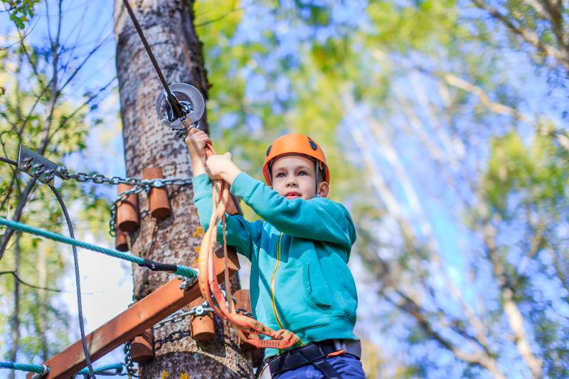 Eine Familie ist im Early Bird Familienurlaub im Klettergarten