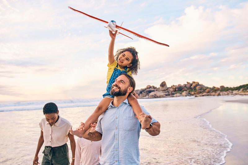 Familie läuft zusammen am Strand an der Wasserkante entlang