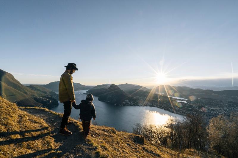 Vater und Sohn stehen auf einem Berggipfel und genießen die Aussicht