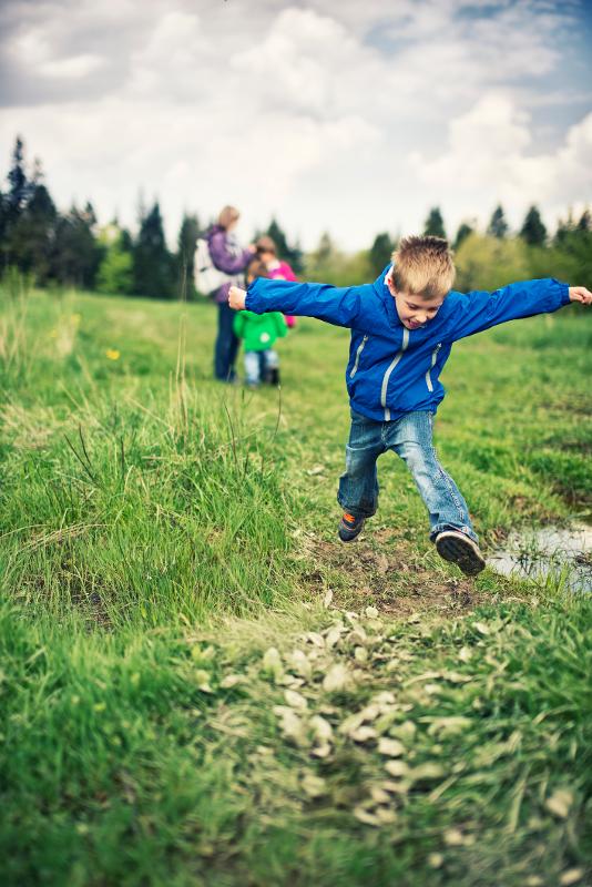 Kinder springen über eine Wiese