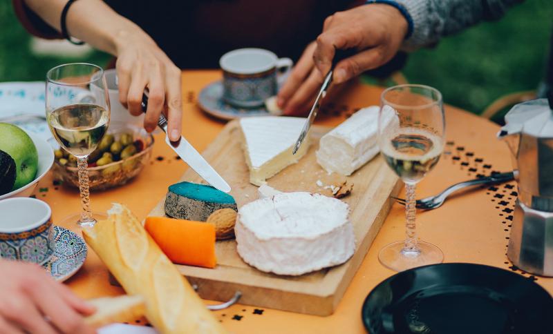 Gedeckter Tisch mit Baguette und verschiedenen Käsesorten