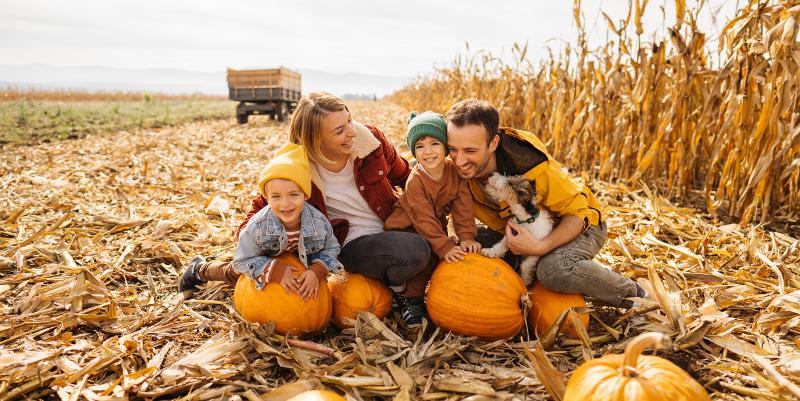 Familie posiert auf Familienreisen Herbstferien mit Kürbissen