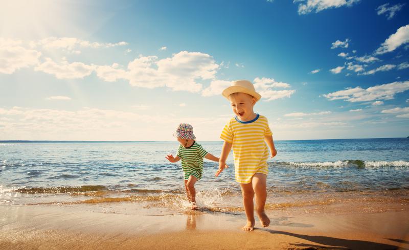 Zwei Jungen machen bei einer Familienreise Mallorca ein Wettrennen am Strand