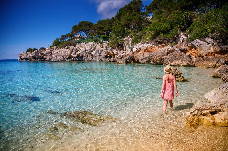 Eine Frau spaziert bei einer Familienreise Mallorca durchs Wasser