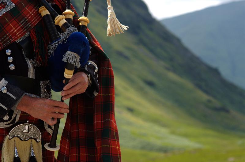  Dudelsackspieler mit Dudelsack in der Natur einer Familienreise Schottland detailliert