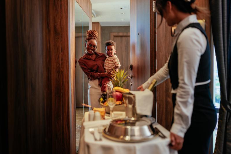 Mutter und Kind bekommen essen im Familienurlaub All Inclusive
