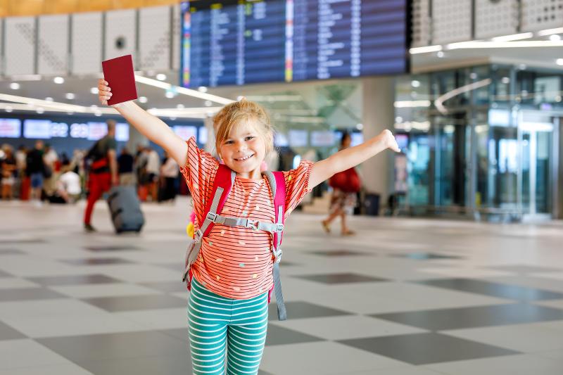 Ein Kind am Flughafen mit seinem Pass im Familienurlaub Andalusien
