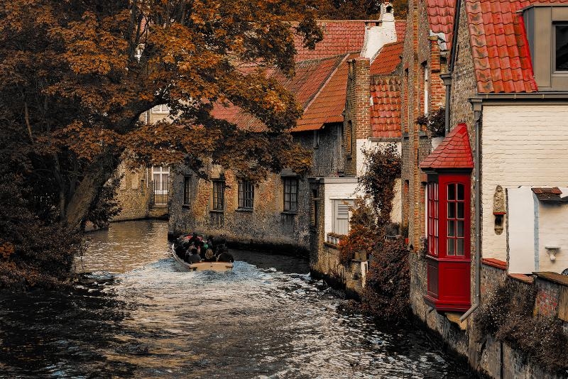 Eine Familie genießt eine entspannte Bootsfahrt auf einem malerischen Kanal im Familienurlaub Belgien