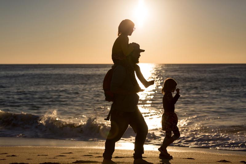 Vater und Kinder gehen am Strand im Familienurlaub Costa de la Luz 