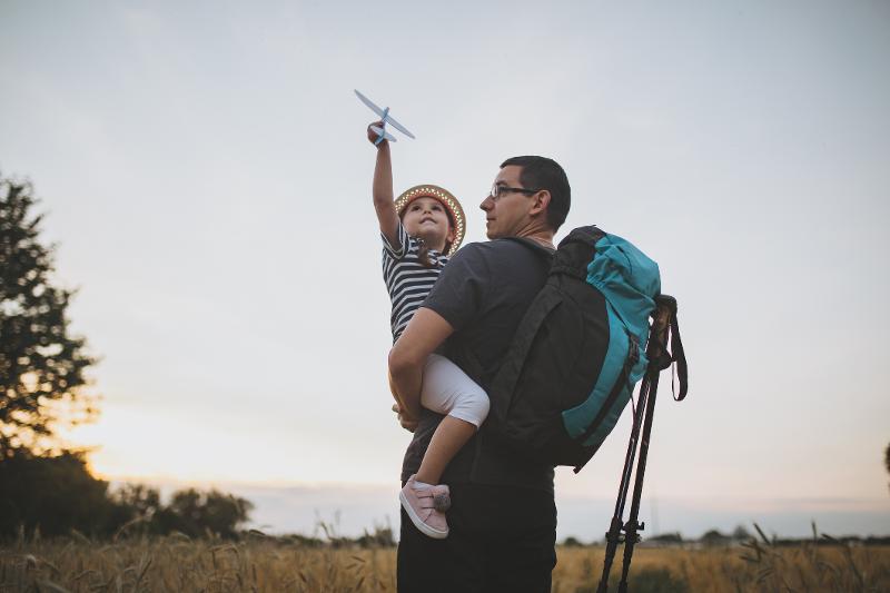 Vater und Kind stehen im Familienurlaub in Deutschland zusammen auf einem Feld