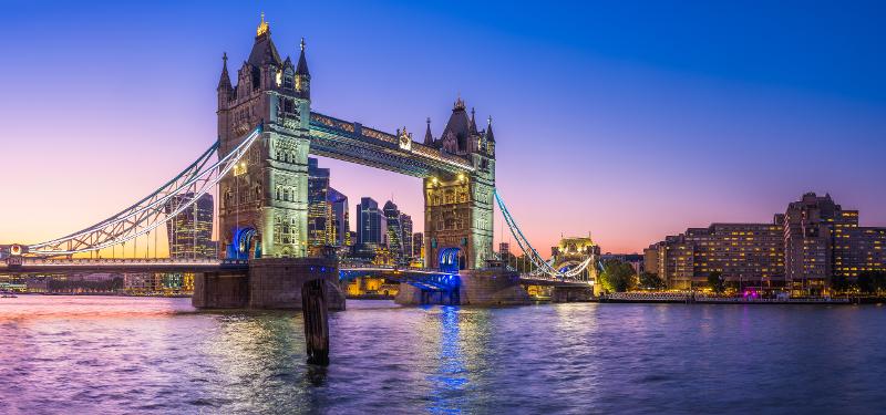 Blick auf die beleuchtete Tower Bridge in London bei Sonnenuntergang im Familienurlaub England