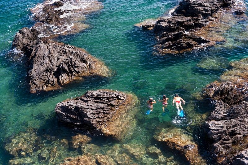  Kinder schnorcheln im blauen Wasser im Familienurlaub Frankreich am Meer