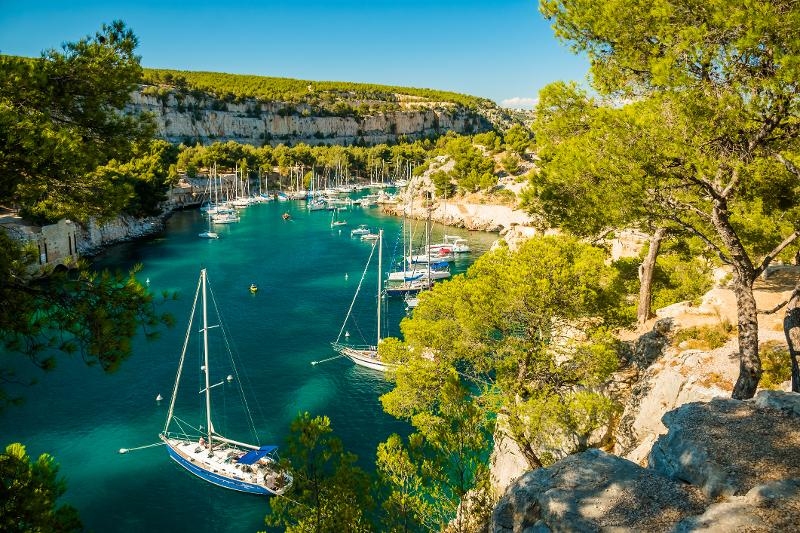  Bucht mit türkisblauem Wasser umrandet von begrünten Felsen im Familienurlaub Frankreich Côte d’Azur