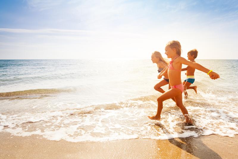  Drei Kinder rennen am Meer im Familienurlaub Frankreich Mittelmeer