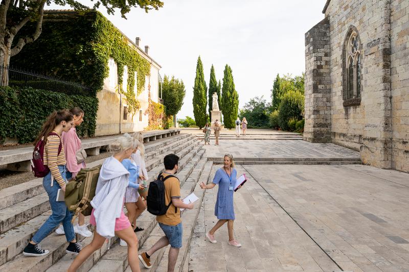 Eine Familie die von einer Reiseleiterin durch eine historische Stätte im  Familienurlaub Frankreich geführt wird 