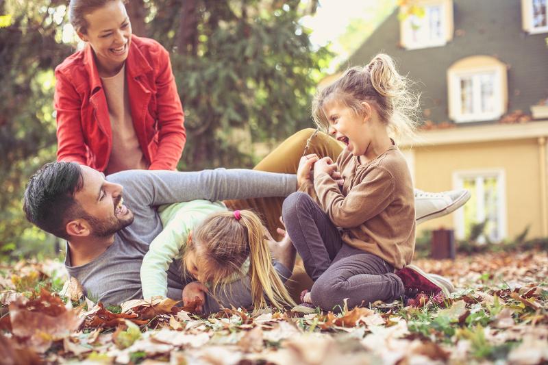 Familie spielt im Familienurlaub Herbstferien in bunten Blättern