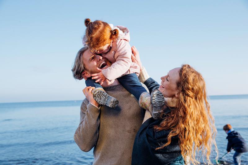 Eltern und Kinder haben Im Familienurlaub Herbstferien gemeinsam viel Spaß am Strand