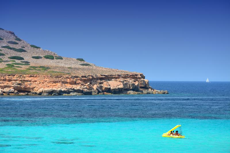 Eine Familie fährt im Familienurlaub Ibiza mit einem Tretboot