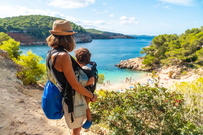 Eine Mama mit Kind in der Trage wandert im Ibiza Familienurlaub