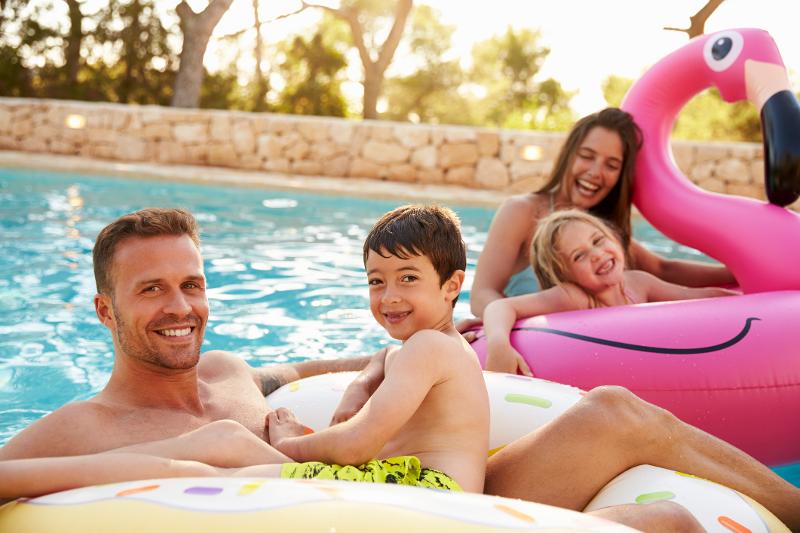 Eine Familie badet im Familienurlaub Ibiza mit Schwimmringen