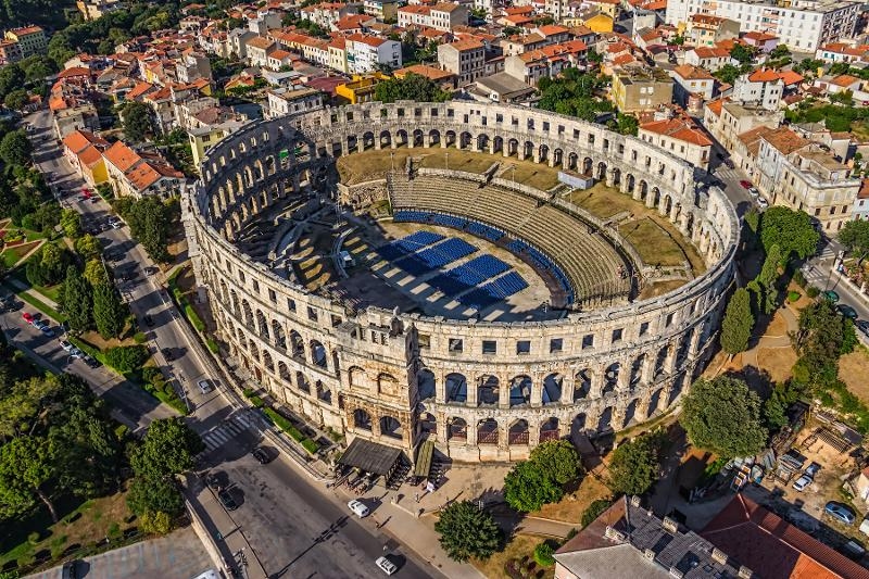 Im Zentrum ist das Amphitheater von oben zu sehen. Weitere Häuser und Grünanlagen befinden sich um die Arena im Familienurlaub Istrien
