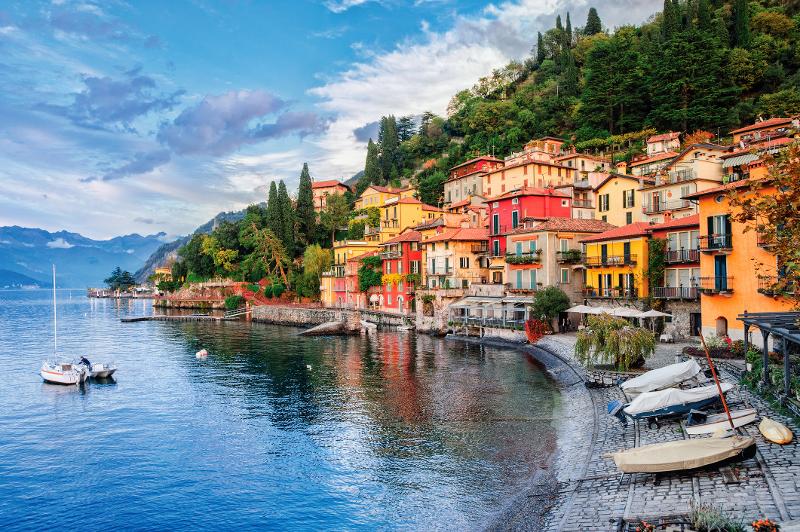  Ein paar Boote liegen in der Bucht im seichten Wasser, bunte Häuser stehen im Hintergrund im Familienurlaub Italien Ferienhaus