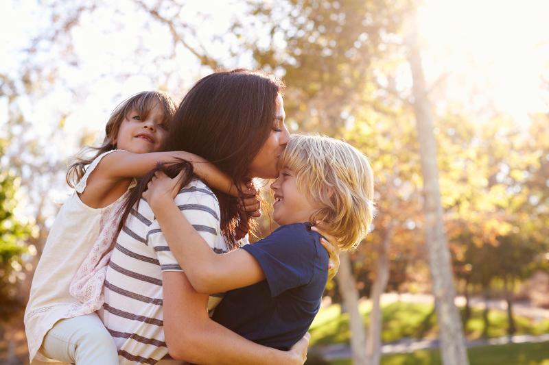 Mutter und Kinder umarmen sich im Familienurlaub Lüneburger Heide All Inclusive.