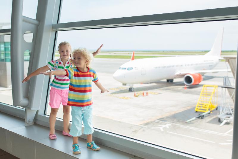 Zwei Kinder am Flughafen vor ihrem Familienurlaub Mallorca Finca