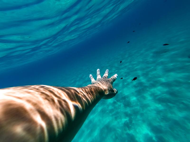 Arm eines Urlaubers Unterwasser beim im Familienurlaub Mallorca Hotel