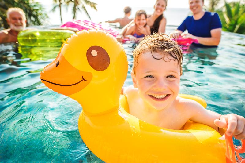 Eine Familie planscht im Pool im Familienurlaub Mallorca und lacht