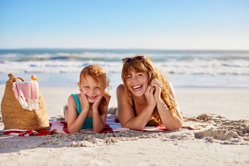 Mutter und Tochter liegen im Familienurlaub Mallorca mit Flug am Strand