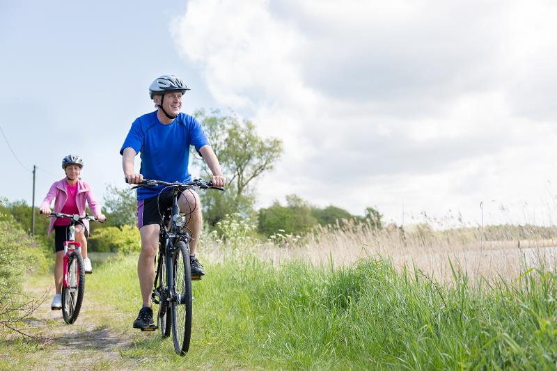 Ein Mann fährt im Familienurlaub Mecklenburg-Vorpommern mit dem Fahrrad durch die Natur