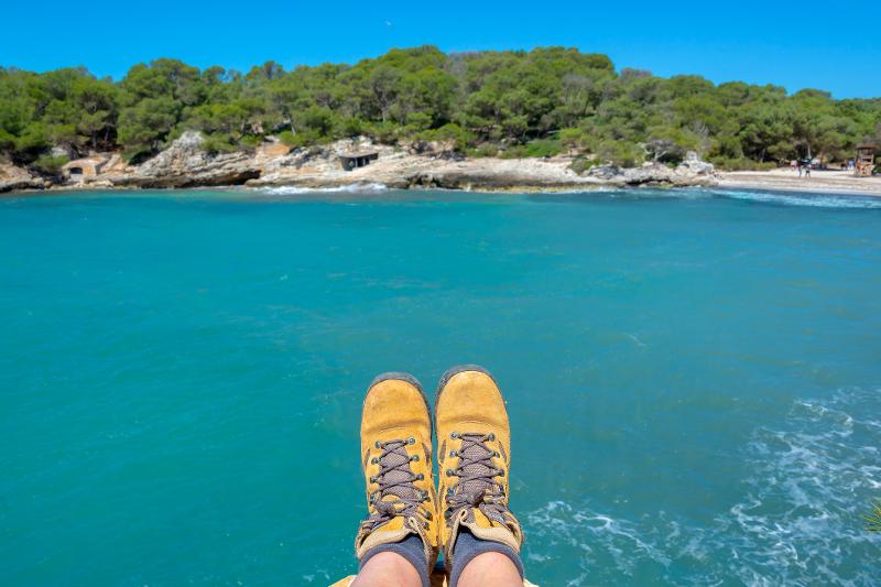 Wanderschuhe vor dem Meer und der Küste im Familienurlaub Menorca