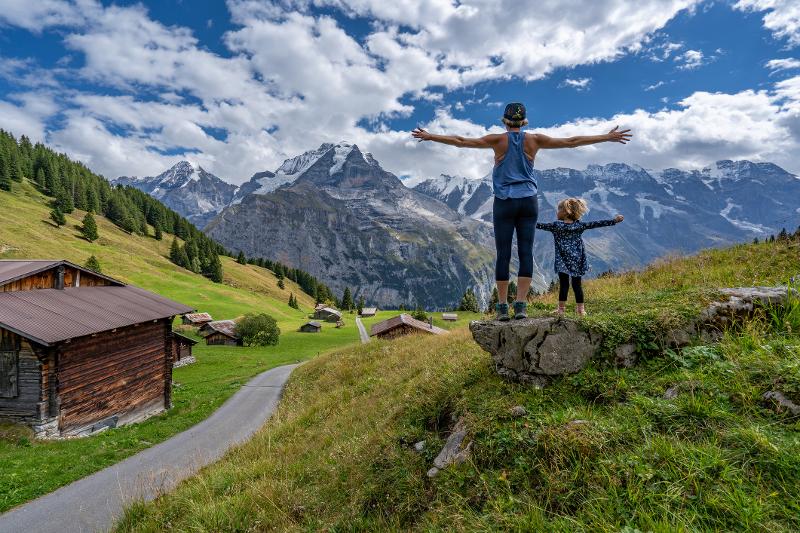  Mutter mit Kind auf einem Stein in den Bergen im Familienurlaub Österreich Hotel