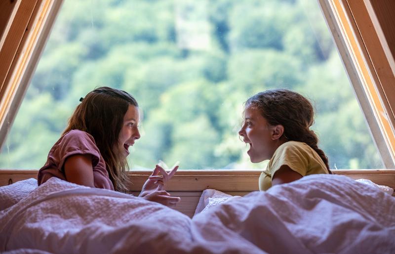  Zwei Mädchen im Bett mit Aussicht auf die Natur im Familienurlaub Österreich Hotel