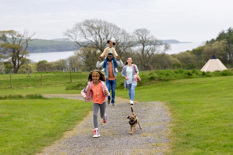 Eine fröhliche Familie genießt ihren Spaziergang im Familienurlaub Schottland