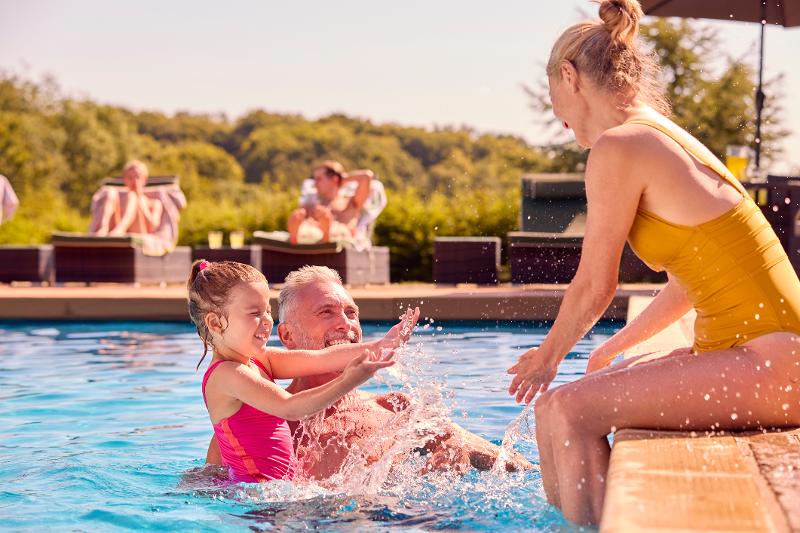 Eine Familie, die im Familienurlaub Spanien All Inclusive im Pool planscht