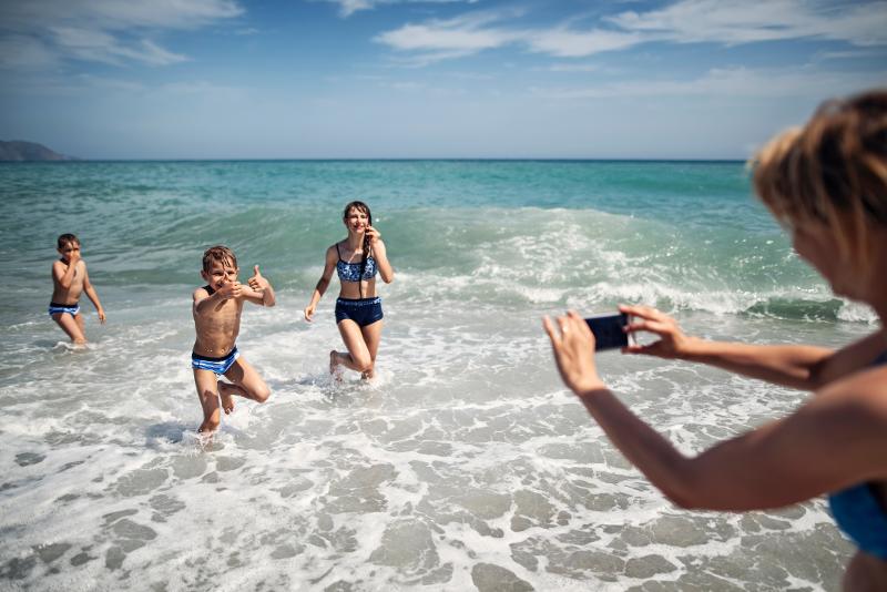 Kinder spielen in dem Wellen des Meeres im Familienurlaub Spanien