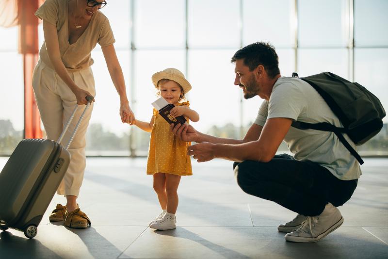  Familie am Flughafen mit Koffer und Reisepass in den Familienurlaub Südengland
