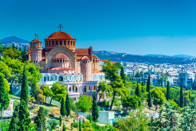 Die St Paul Kathedrale im Familienurlaub Thessaloniki umringt von grünen Bäumen und die Stadt im Hintergrund