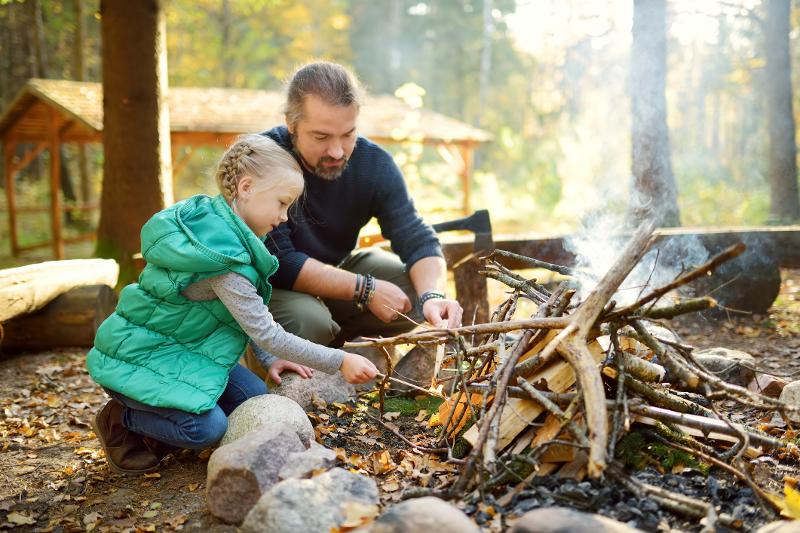 Eine Familie errichtet ein Lagerfeuer im Familienurlaub Thüringer Wald All Inclusive 