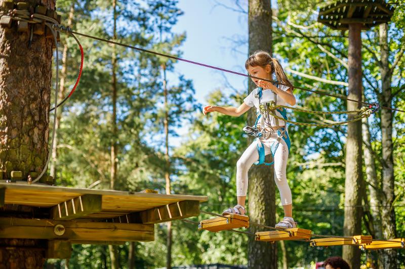 Mädchen im Hochseilgarten während ihres Familienurlaubs in Tirol