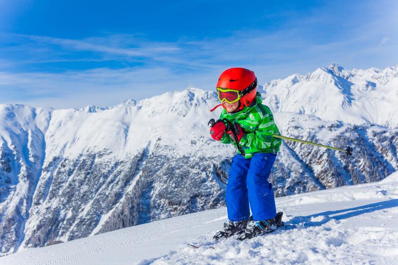 Ein Kind in Skikleidung während eines Familienurlaubs in Tirol