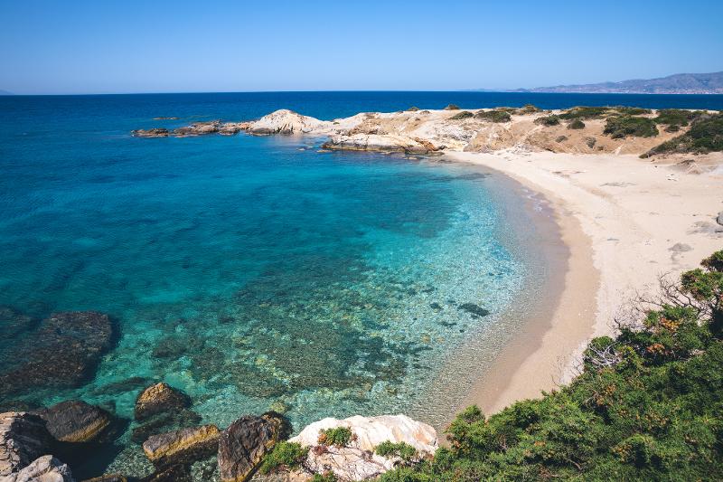Ein einsamer Strand mit klarem, blauem Wasser und feinem Sand im Familienurlaub Griechenland günstig