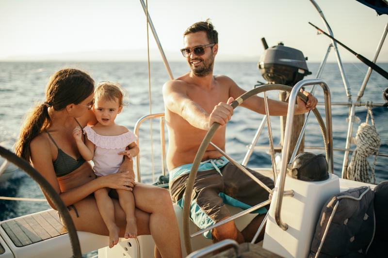 Eine Familie genießt eine Bootsfahrt auf dem Meer während ihrem günstigen All Inclusive Familienurlaub