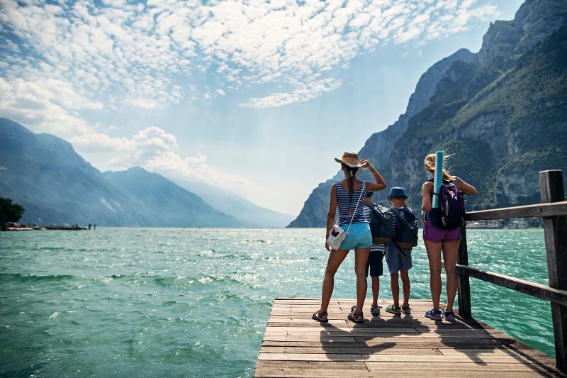  Eine Familie steht auf dem Steg und blickt auf den Gardasee im Italien Urlaub mit Kindern All Inclusive