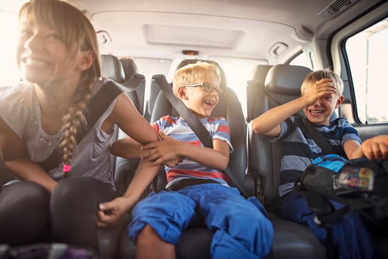  Drei Kinder im Auto haben Spaß bei ihrer Anreise in den Italien Urlaub mit Kindern eigene Anreise